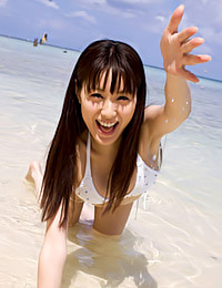 Beautiful Asian teen temptress Minami Matsumaka is posing in her white bikini on the beach.
